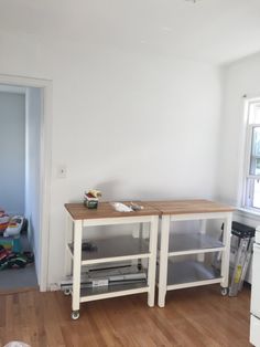 an empty room with two tables in the middle and one on the floor next to it