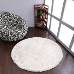 two round rugs sitting on top of a wooden floor next to a book shelf