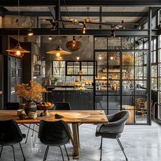 an industrial style dining room with black walls and wooden table surrounded by chairs, hanging lights and potted plants