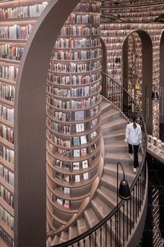 a spiral staircase in the middle of a library filled with books