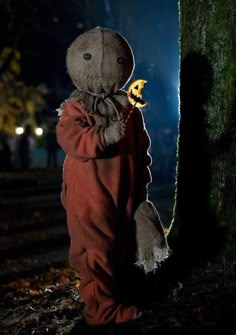 a stuffed animal is standing next to a tree