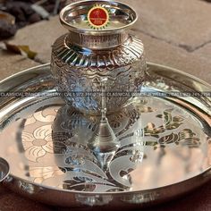 an ornate silver plate with a candle holder on it