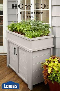 two planters with plants growing out of them on a porch next to a door