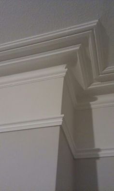 the corner of a room with white paint and molding on the wall above it