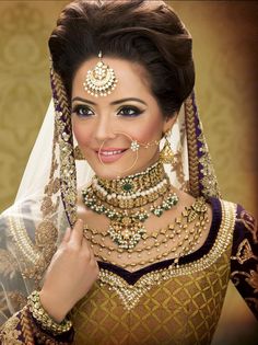 a woman in a bridal outfit with jewelry on her neck and headpieces