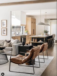 a living room filled with furniture next to a kitchen