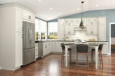 a large kitchen with white cabinets and wood floors