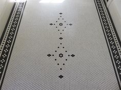 a black and white tiled floor with an intricate design on the bottom half of it