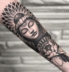 a buddha tattoo on the arm with flowers and leaves around it's head, in black and white