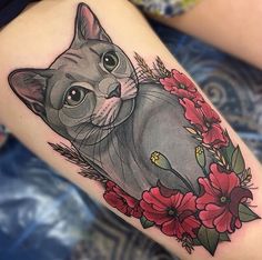 a cat with flowers on it's thigh is shown in this tattoo art photo