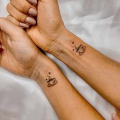 two hands holding each other with tattoos on them