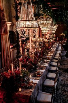 a long table with many chairs and chandeliers