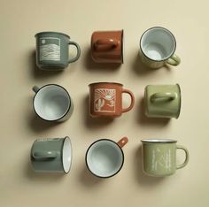 there are many coffee cups on the table together, all different colors and shapes in each mug