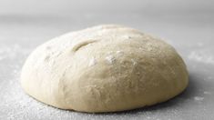 a close up of a doughnut on a table with flour sprinkled around it