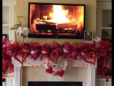 a fireplace decorated for valentine's day with red and pink decorations