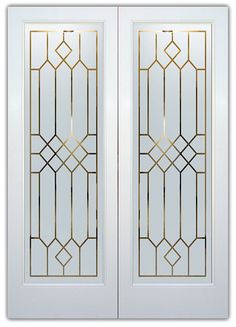 a pair of white doors with gold trimmings and glass panels on each side