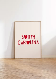 a white framed poster with the word south carolina printed on it in red and black