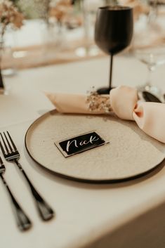 a place setting with napkins, silverware and wine glasses on the table at a wedding reception