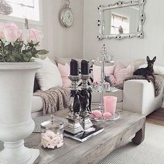 a living room filled with lots of furniture and flowers on top of a coffee table