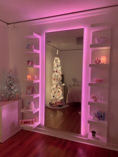 there is a christmas tree in the corner of this room with pink lights on it