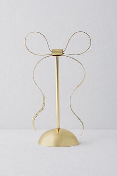 a gold candle holder with a ribbon tied around it