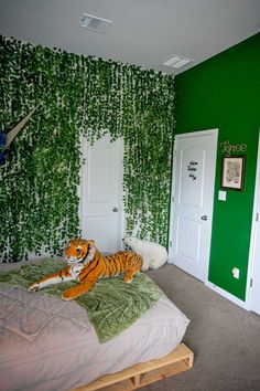 a bedroom decorated in green and white with a tiger laying on the bed