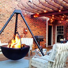 a fire pit sitting on top of a wooden deck next to white chairs and tables