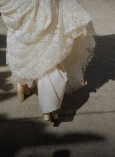 a woman is walking down the street in her wedding dress