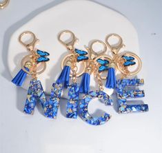 three pairs of blue and gold key chains with the word dance spelled out in large letters