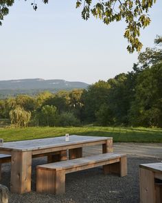 a picnic table and benches in the middle of a field