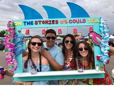 four people standing in front of a sign that says oh the stories we could tell