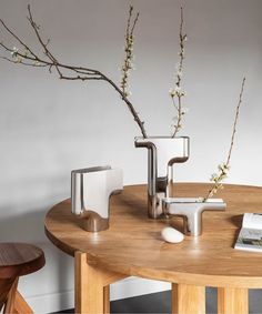 a wooden table topped with two vases filled with flowers next to a computer mouse