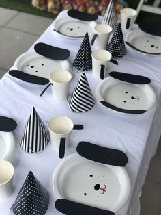 a table topped with black and white plates and cups