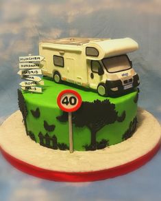 a green cake with a camper on top and street signs in the middle,