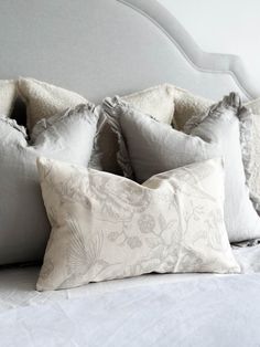 a bed with four pillows on top of it and one pillow has ruffled edges