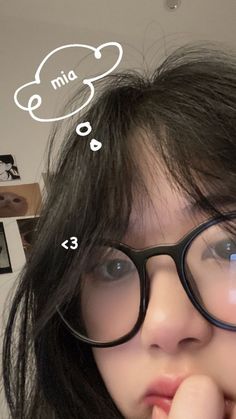 a girl with glasses has her finger under her nose and thought bubble above her head