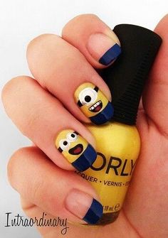 a person holding a yellow and blue nail with cartoon characters on it