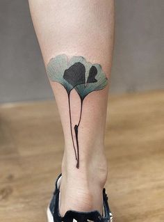 a woman's foot with a flower tattoo on the left side of her leg