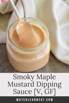 a spoon in a small jar filled with sauce and the words smoky maple mustard dipping sauce v, gf