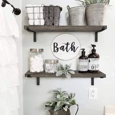 a bathroom with two shelves above the toilet and some plants on the shelf below it