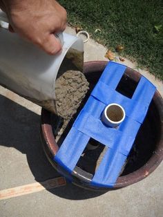 a person pouring cement into a hole in the ground