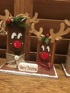 three christmas bags with reindeer noses and bows on them, sitting on top of a wooden table