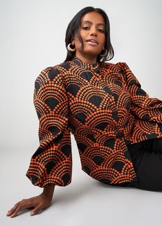 Style#: 2115/ P2115 Meet the Kari blouse with beautiful puff sleeves and button-up front in our Black Amber Dots African-inspired print. Easy to dress up or down, this blouse is a great addition to any fall wardrobe. Features: Mandarin Collar Puff Sleeve Elastic at the sleeve 97% Cotton/3% Spandex Stretch Poplin​ Designed in the USA, imported Care Instructions: Machine wash cold on a gentle cycle with non-chlorine detergent. Do not bleach. Hang to dry. Iron on low setting. Models: Size: XS Heigh Fall Printed Tops With Balloon Sleeves, Fall Tops With Printed Balloon Sleeves, Fitted Long Sleeve Blouse With Elastic Sleeves, Fall Tops With Balloon Sleeves And Printed Details, Fitted Blouse With Elastic Sleeves For Fall, Black Balloon Sleeve Blouse For Spring, Polka Dot Button-up Blouse For Fall, Balloon Sleeve Blouse With Buttons For Fall, Fitted Black Blouse With Button Cuffs