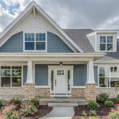 a house with blue siding and white trim on the front door is pictured in this image