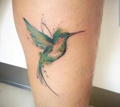 a hummingbird tattoo on the leg of a person's legs with watercolors