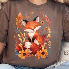 a woman wearing a t - shirt with an image of a fox and flowers on it