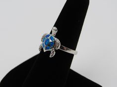 Top of ring height: 16.7mm Top of ring width: 14.4mm Band width: 2.4mm Shank width: 2.4mm Stone material: blue lab created opal Stone setting: inlay setting Metal: 925 sterling silver Plating: rhodium plated Finish: high polish Ring box color in picture may not be the color you receive. All orders ship via USPS first class mail. I will process your order and ship it within 1 business day of payment. I only ship within the United States. Please don't hesitate to message me with any questions or c Blue Stackable Jewelry As Gift, Adjustable Small Jewelry For Anniversary, Adjustable Nickel-free Opal Ring As A Gift, Blue Opal Ring Gift, Blue Open Ring Jewelry For Gift, Adjustable Open Opal Ring As Gift, Adjustable Open Opal Ring For Gift, Adjustable Open Opal Ring Gift, Adjustable Blue Open Ring Jewelry