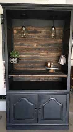 an entertainment center made out of wood and metal with two lights on the top shelf