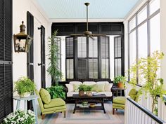 a living room filled with furniture and lots of plants on top of it's windows