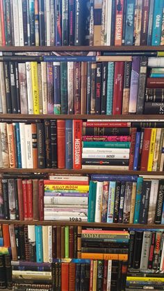 a bookshelf filled with lots of different types of books on top of each other